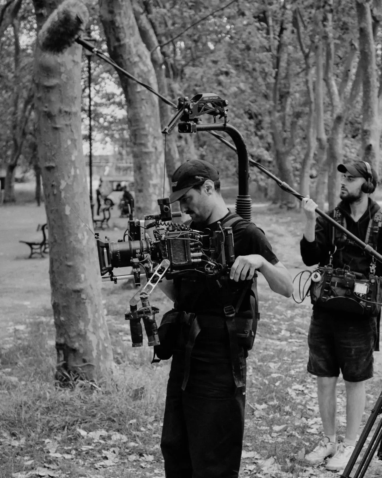 Operator with a gimbal rig filming outdoors.
