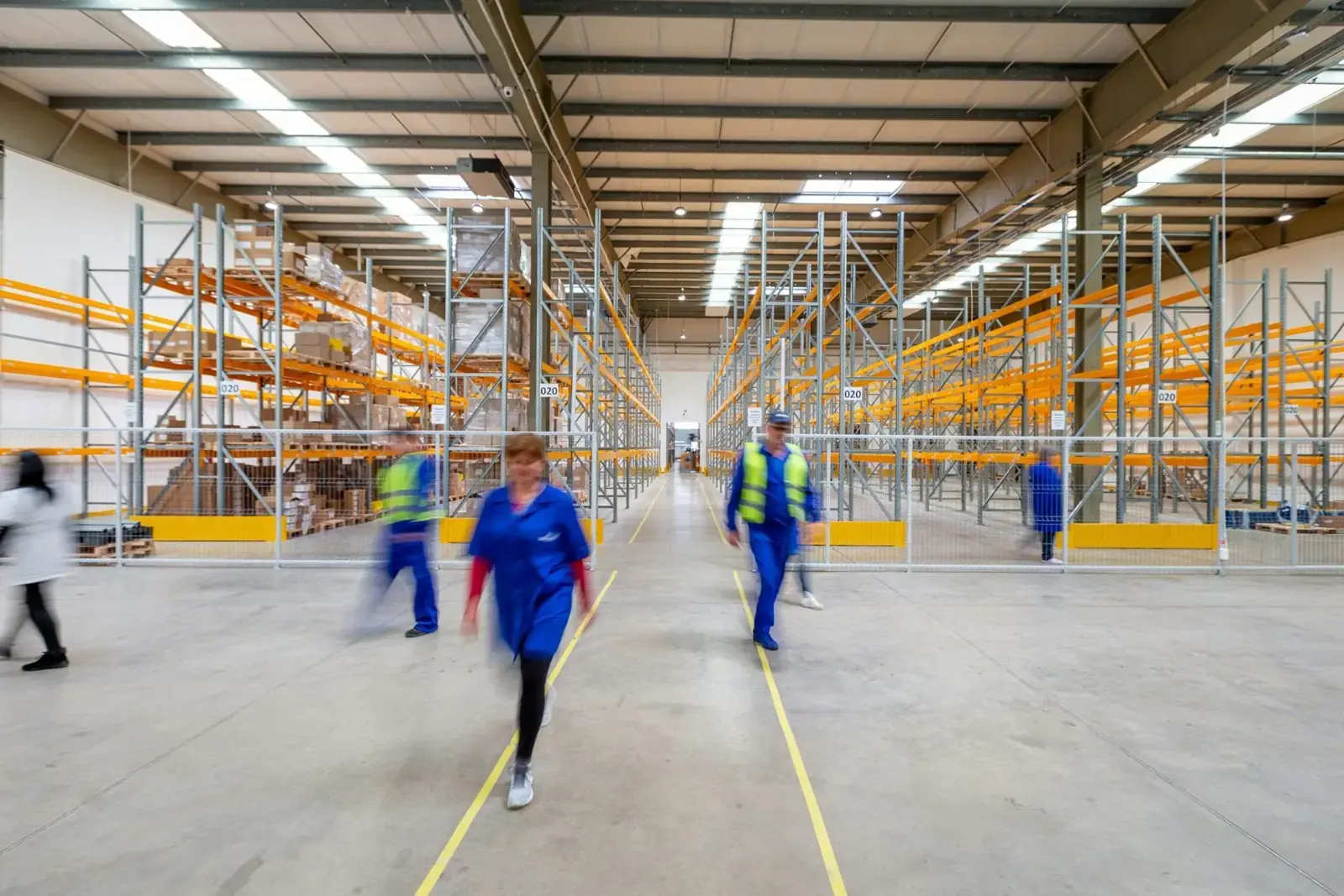Busy warehouse floor with staff moving between racks.