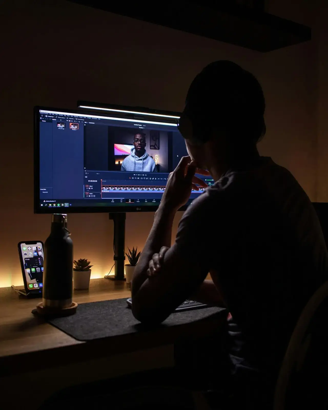 Editor working at a monitor in a dark room.